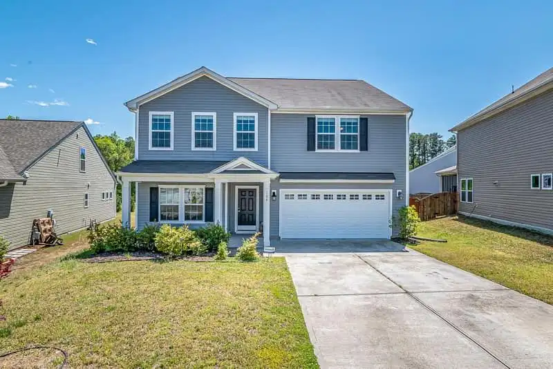 The front of a two-story suburban house with a lawn and a driveway