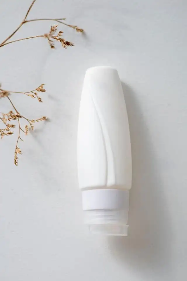 A white pump bottle arranged with dried stems